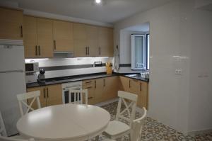 a kitchen with a white table and white chairs at Tras Do Atrio Casa en el Centro de Betanzos in Betanzos