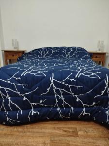 Bett mit blauer Bettdecke und Zweigen darauf in der Unterkunft Apartamento centro young in Young