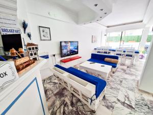a living room with a couch and a tv at Golden Beach Hotel in Didim
