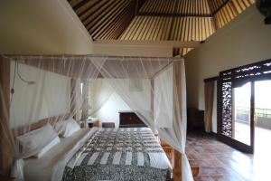 a bedroom with a canopy bed in a room at Uma Capung Mas Cottage in Ubud +37 photos