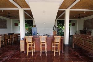 a bar in a restaurant with wooden stools at Uma Capung Mas Cottage in Ubud