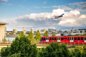 a plane is flying over a red train on a bridge at Holiday Inn Express London - ExCel, an IHG Hotel in London