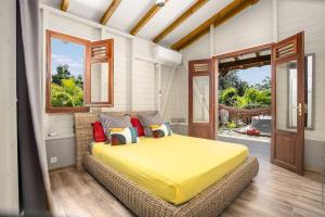 勒弗朗索瓦Bungalow Cactus的卧室里有一张大床，床上铺着黄色毯子