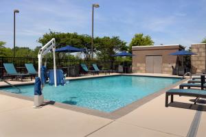a swimming pool with chairs and umbrellas at Hampton Inn & Suites Huntsville Research Park Area in Huntsville