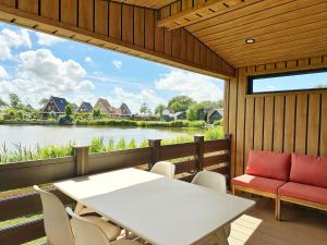 a dining room with a table and chairs and a large window at Chalet 503a op Recreatiepark De Wielen in Sint Maarten