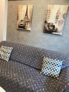 a couch with two pillows and pictures on the wall at M+V apartment in Alexandroupoli