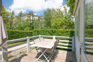 a table and chairs on the balcony of a house at Camping Onlycamp La Colombière in Pesmes +3 photos