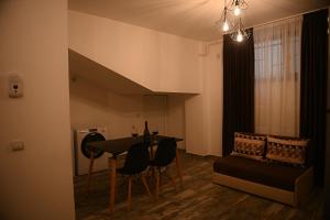 a living room with a table and chairs and a couch at Arin l Aparthotel #1 in Craiova