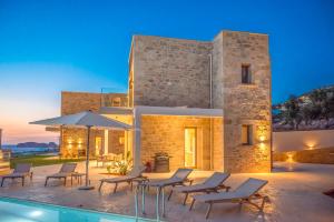 a villa with a swimming pool in front of a building at Falasarna's Dream in Kissamos