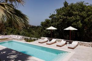 a swimming pool with lounge chairs and umbrellas next to a pool at Mount Minis - Casa Piero in Syvota