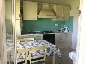 a kitchen with a table and a sink and a stove at Villetta mare Erica in Santa Teresa Gallura