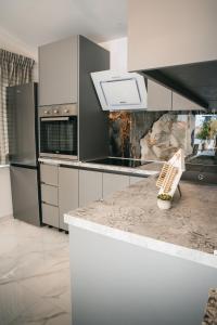 a kitchen with white cabinets and a counter top at Summerhouse Blanka 2024 in Vir