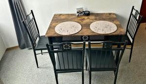 a table with four chairs and a wooden table and chairs at Henneberger Hof in Münnerstadt +14 photos