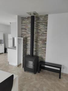 a black stove in a room with a brick wall at Chez CHARLETTE in Les Malots