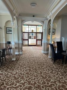 a hallway with chairs and tables in a building at Clifton Hotel in Scarborough