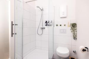 Un baño blanco con ducha y WC. en Design Suite! Familie - Küche - Zentral, en Wuppertal