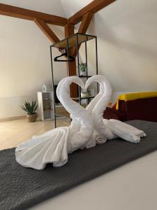 a couple of swans forming a heart on a bed at STYLISH STUDIO APARTMENT BURE in Murter