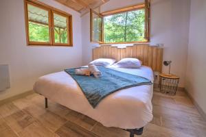 a bedroom with a bed with a teddy bear on it at Le Chalet du Manoire in Saint-Laurent-sur-Manoire