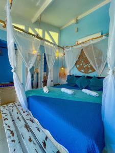 a blue bedroom with a large blue bed with curtains at ASAS DEL MAR - SUITES in Canoa Quebrada +50 photos