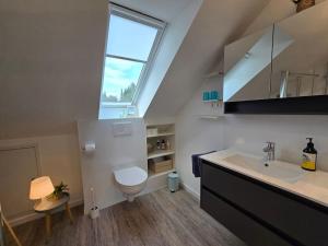 a bathroom with a sink and a toilet and a window at Wanderers Inn Heidschnuckenweg in Undeloh
