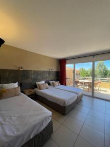 a hotel room with two beds and a balcony at Hôtel Le Maritime in Argelès-sur-Mer +41 photos