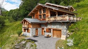 a log house with a porch and a balcony at mini duplex dans chalet in Saint-François-Longchamp
