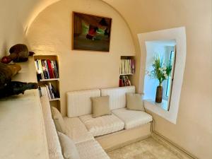 a living room with a white couch and a window at Charming Villa for nature lovers in Theotoky Estate Vineyard and olive mill in Corfu