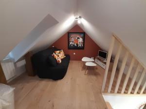 a living room with a black couch and a staircase at Gite Chez Laurette 12 in Sainte-Eulalie-dʼOlt