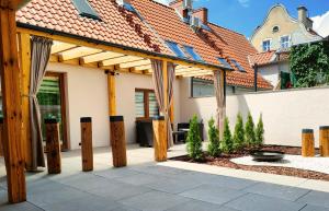 a wooden pergola in front of a house at Kamienica Na Nowo Apartamenty Warszawska in Mrągowo