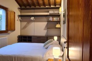 Un dormitorio con una cama y una estantería. en CoZy House San Gimignano in the heart of Tuscany, en San Gimignano