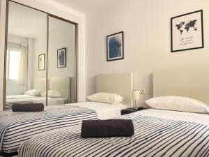 dwa łóżka w pokoju z lustrem w obiekcie Central & Beautiful Apartment by DV Properties #P2 w Maladze +15 zdjęć