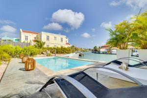 a villa with a swimming pool and a boat at Kas Azul - New water front villa with private pool in Kralendijk