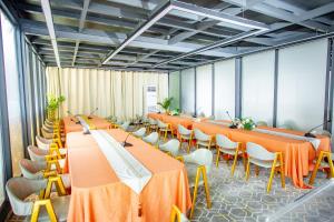 een conferentiezaal met oranje tafels en stoelen bij 520 hôtel & Résidence in Abidjan