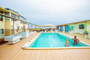 twee kinderen spelen in een zwembad op een gebouw bij 520 hôtel & Résidence in Abidjan