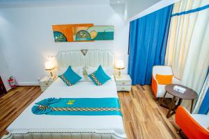 een slaapkamer met een bed met blauwe gordijnen en een tafel bij 520 hôtel & Résidence in Abidjan +9 foto's