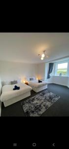a bedroom with two beds and a rug at Farina Holiday apartments in Bridlington