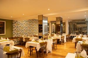 a restaurant with white tables and chairs in a room at Gran Hotel Parana in Paraná