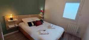 sypialnia z łóżkiem i dwoma ręcznikami na nim w obiekcie Auva - SILS Maison 48 m2 à 5 minutes à pied de la plage w mieście Saint-Aubin-sur-Mer