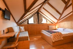 a bedroom with a bed and a desk in a room at Hotel El Laresh in Moena