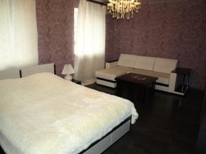 a bedroom with two beds and a couch and a table at Hotel Zebra in Yoshkar-Ola