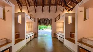 ein Flur mit zwei Betten und einer Tür zu einem Zimmer in der Unterkunft Viajero Tayrona Hostel & Ecohabs in Buritaca + 55 Fotos