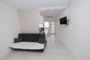 uma sala de estar com um sofá preto e branco em Hardi 1 em Trebinje