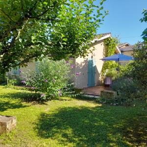 a house with a green door and a yard at la petite maison in Espiet