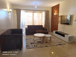 a living room with a couch and a table at Elegant rooms and apartment with pool in Nyali in Mombasa