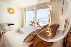 a person sitting on a bed with a glass orb at Mara's Apartments Torremolinos SeaViews -Beachfront - Duplex Penthouse in Torremolinos