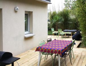 eine Terrasse mit Tisch und Stühlen auf einem Deck in der Unterkunft Maison mer et campagne in Pluvigner