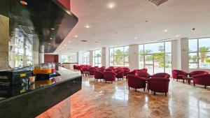 a large room with red chairs and a bar at Monarque El Fatimi Mahdia in Mahdia