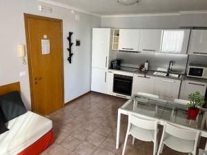 a small kitchen with a glass table and a bed at Hotel Lydia in Grado