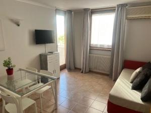 a living room with a bed and a glass table at Hotel Lydia in Grado