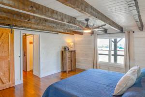 a bedroom with a blue bed and a window at about 10 Mi to Downtown Murfreesboro Area Cabin in Lascassas